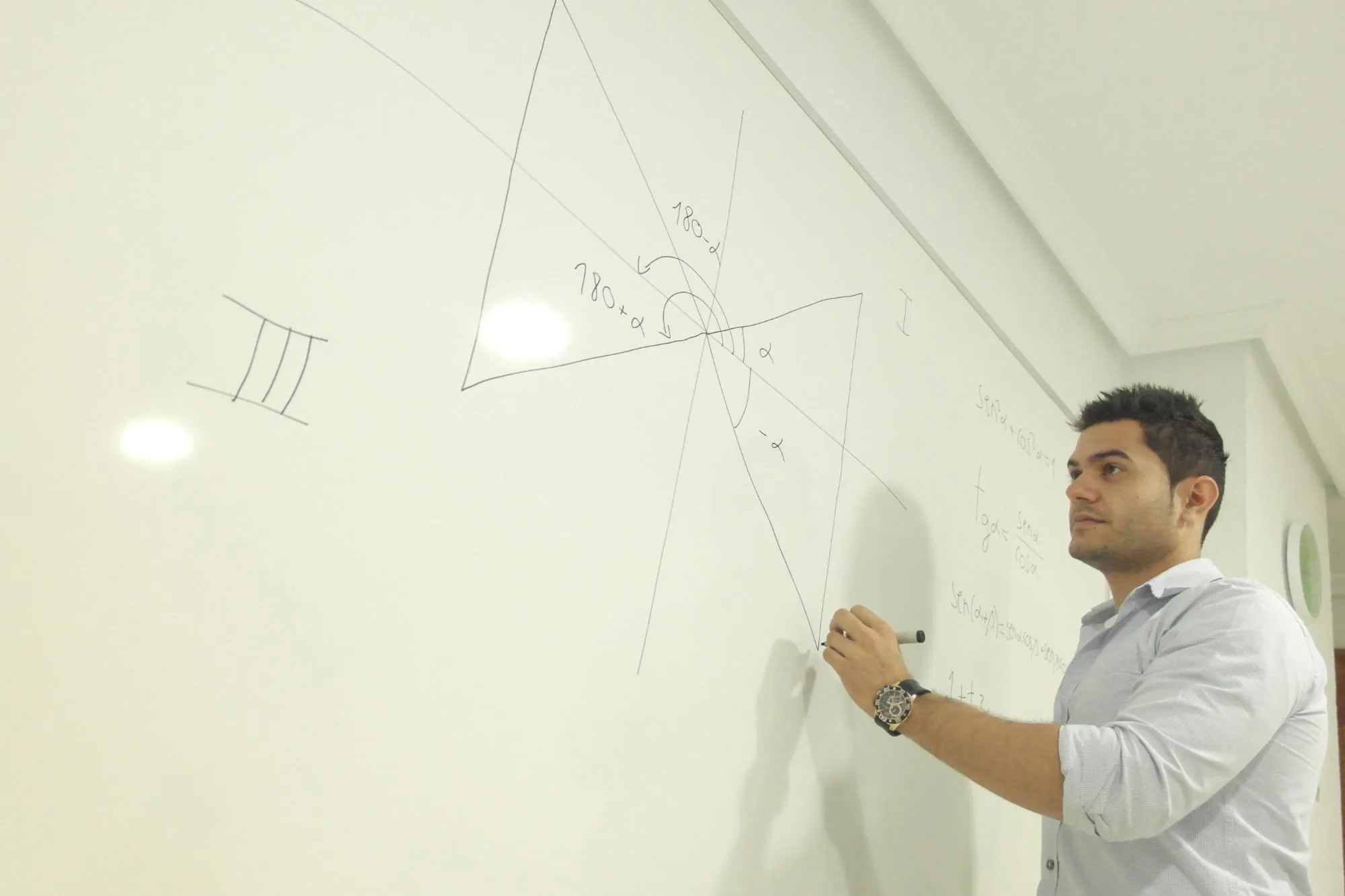 Un profesor de la academia escribe en la pizarra